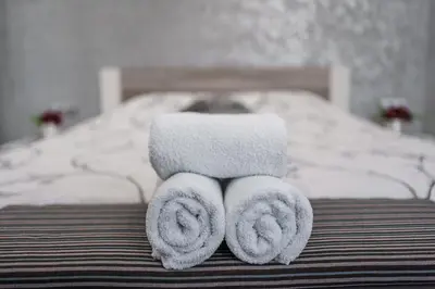 a pile of towels sitting on top of a bed at City Apartments - a brand new luxury & comfy. in Asenovgrad