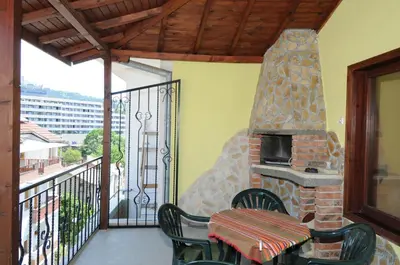 a patio with a stone fireplace on a balcony at Family Hotel Studio in Sandanski