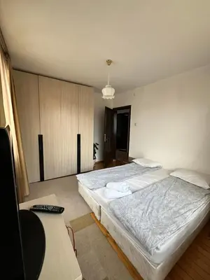 a large bedroom with two beds and a desk at Bayrakova Guest House in Dobrinishte