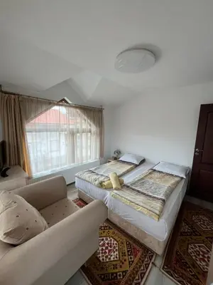 a bedroom with a large bed and a couch at Bayrakova Guest House in Dobrinishte