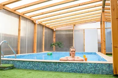 a woman is sitting in a swimming pool at Hotel Saint Nicola in Banya