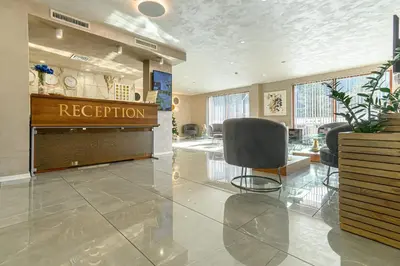 a reception lobby with a reception desk and chairs at Spa Hotel Orbita in Blagoevgrad