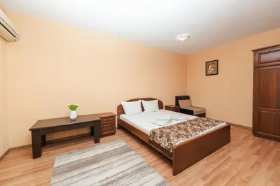 a bedroom with a bed and a table at Семеен хотел Свети Георги in Sandanski