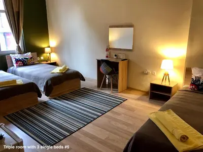 a hotel room with two beds and a mirror at SKYLER GUEST HOUSE in Plovdiv
