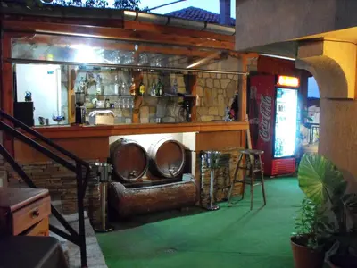 a bar with a bench in the middle of a room at Family Hotel Ogi in Asenovgrad