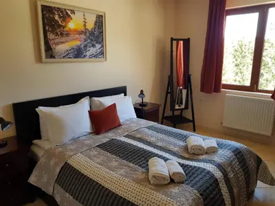 a bedroom with a bed with two towels on it at Панорама Стойките Уют in Stoykite