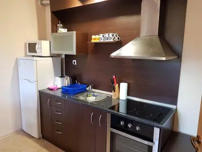 a small kitchen with a stove and a refrigerator at Панорама Стойките Уют in Stoykite