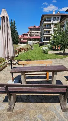 a picnic table and an umbrella next to a building at Панорама Стойките Уют in Stoykite