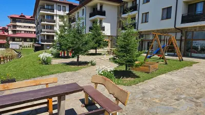 a park with a wooden bench and a playground at Панорама Стойките Уют in Stoykite