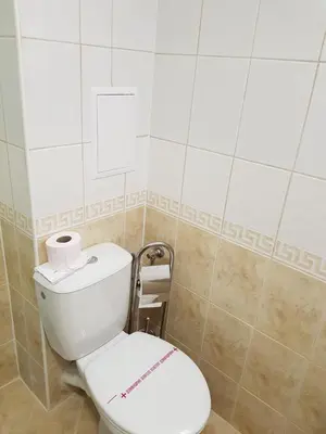 a bathroom with a white toilet in a room at Панорама Стойките Уют in Stoykite
