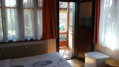a bedroom with a bed and a window with a view at Guest House Bolyarka in Koprivshtitsa
