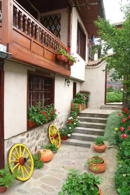 a house with yellow wheels on the side of it at Guest House Bolyarka in Koprivshtitsa