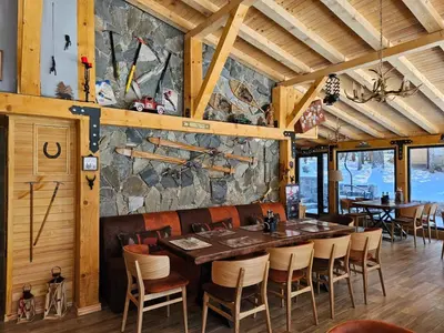 a dining room with a stone wall and a table and chairs at Algara hut in Panichishte