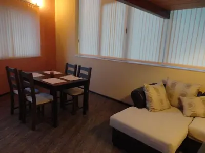 a room with a table and a couch and a table and chair at Mountain Dreams Apartment in Sapareva Banya