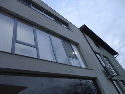 a building with large windows on the side of it at Mountain Dreams Apartment in Sapareva Banya
