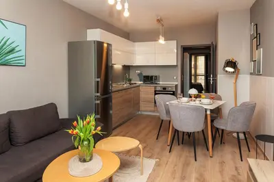 a kitchen and a living room with a couch and a table at К's City Living with Free Parking in Plovdiv