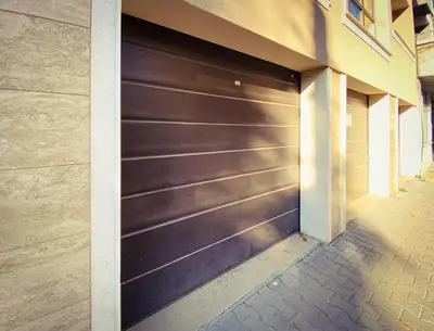 a brown garage door on a building with a sidewalk at К's City Living with Free Parking in Plovdiv
