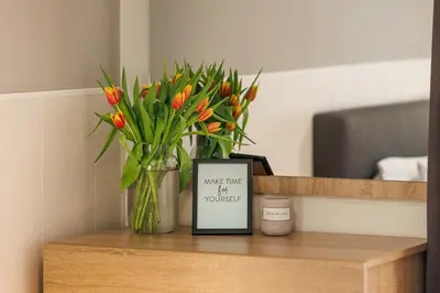 a vase of tulips and a picture on a table at К's City Living with Free Parking in Plovdiv