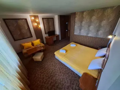 a hotel room with a large bed and a couch at Korona Hotel in Blagoevgrad