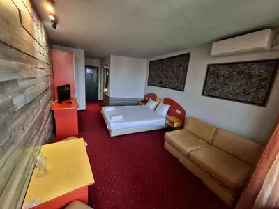 a hotel room with a bed and a couch at Korona Hotel in Blagoevgrad