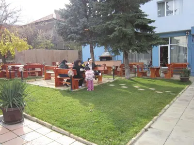 a group of people sitting on benches in a park at Germanea Hotel in Sapareva Banya