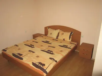 a bedroom with a bed with a wooden headboard at Germanea Hotel in Sapareva Banya