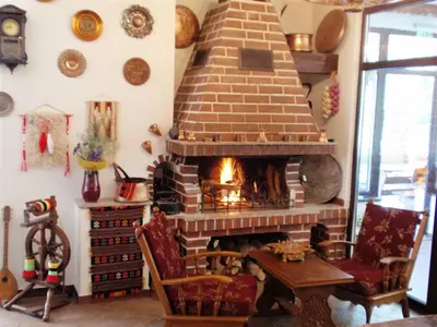 a living room with a fireplace and a table and chairs at Family Hotel Emaly 2 in Sapareva Banya