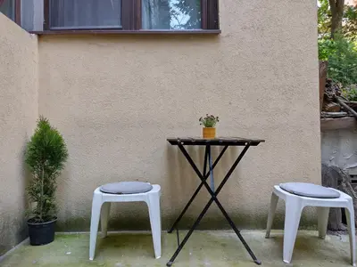 a table and two stools next to a wall at Central Charming Home with Garden near Parking and NDK in Sofia