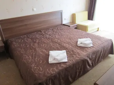 a bedroom with a bed with two towels on it at Хотел Магнолия, Hotel Magnoliya in Panichishte