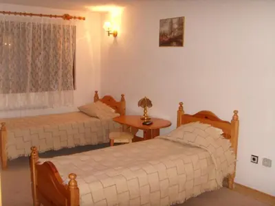 a bedroom with two beds and a table in it at Family Hotel Markony in Pamporovo