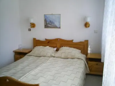 a bedroom with a large white bed with pillows at Family Hotel Markony in Pamporovo