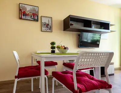 a dining room with a table and chairs and a tv at RIVERSIDE APARTMENTS PLOVDIV with free parking in Plovdiv