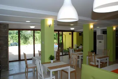 a restaurant with tables and chairs and green walls at Green Hisar Hotel Family in Hisarya