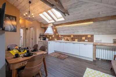 a kitchen with white cabinets and a wooden floor at 2-Bedroom Elegant Apartment in Mediterranean Style in Sofia