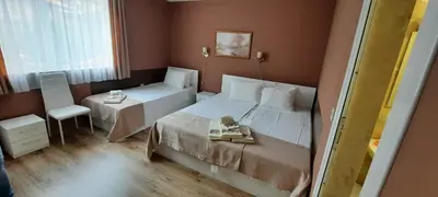 a hotel room with a bed and a table and a chair at MARIANA - guest rooms in Gotse Delchev