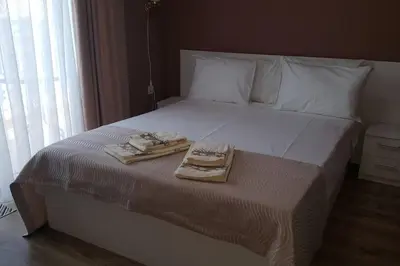 a bed with two towels and a tray on it at MARIANA - guest rooms in Gotse Delchev