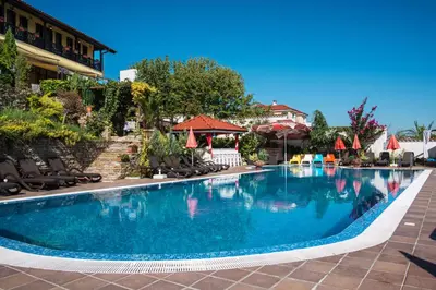 a swimming pool at a resort with chairs and umbrellas at Chiflika Family Hotel in Asenovgrad