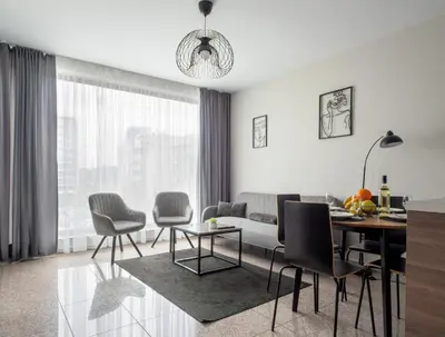 a living room with a couch and a table at Modern Apartment with Parking next to Bulgaria Mall in Sofia