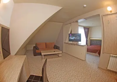 a living room with a staircase with a couch and a television at Vitoshko Lale Hotel in Sofia