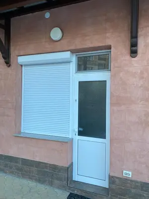 a building with a garage door and a window at Apartments DIEM in Samokov