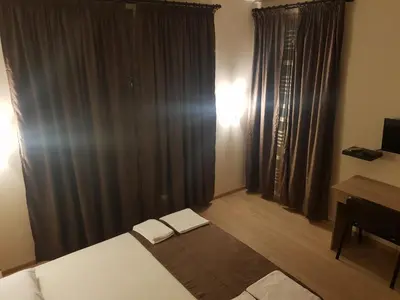 a bedroom with a bed and a window with curtains at Twain Apart&Rooms in Sofia