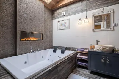 a bathroom with a large tub and a fireplace at 1-Bedroom Designer Apartment on Hristo Belchev Str in Sofia