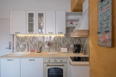 a kitchen with white cabinets and a sink at 1-Bedroom Designer Apartment on Hristo Belchev Str in Sofia