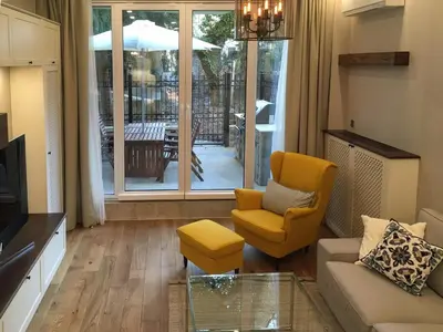 a living room with a couch and a glass table at A luxury apartment with patio and BBQ in Sofia