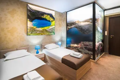 a bedroom with two beds and a painting on the wall at Central Point Boutique Hotel in Sofia