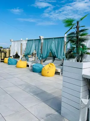 a patio with yellow and blue chairs on a roof at 103 Degrees Hotel & Spa in Sapareva Banya