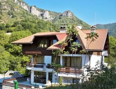 a large house with a mountain in the background at Villa Cherven in Teteven