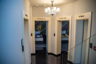 a hallway with four doors and a chandelier at Boutique Guest house 7th Sense in Plovdiv