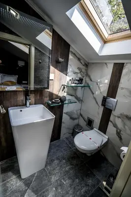 a bathroom with a white toilet and a sink at Boutique Guest house 7th Sense in Plovdiv