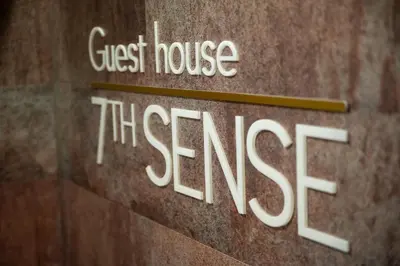 a sign for a guest house in a building at Boutique Guest house 7th Sense in Plovdiv